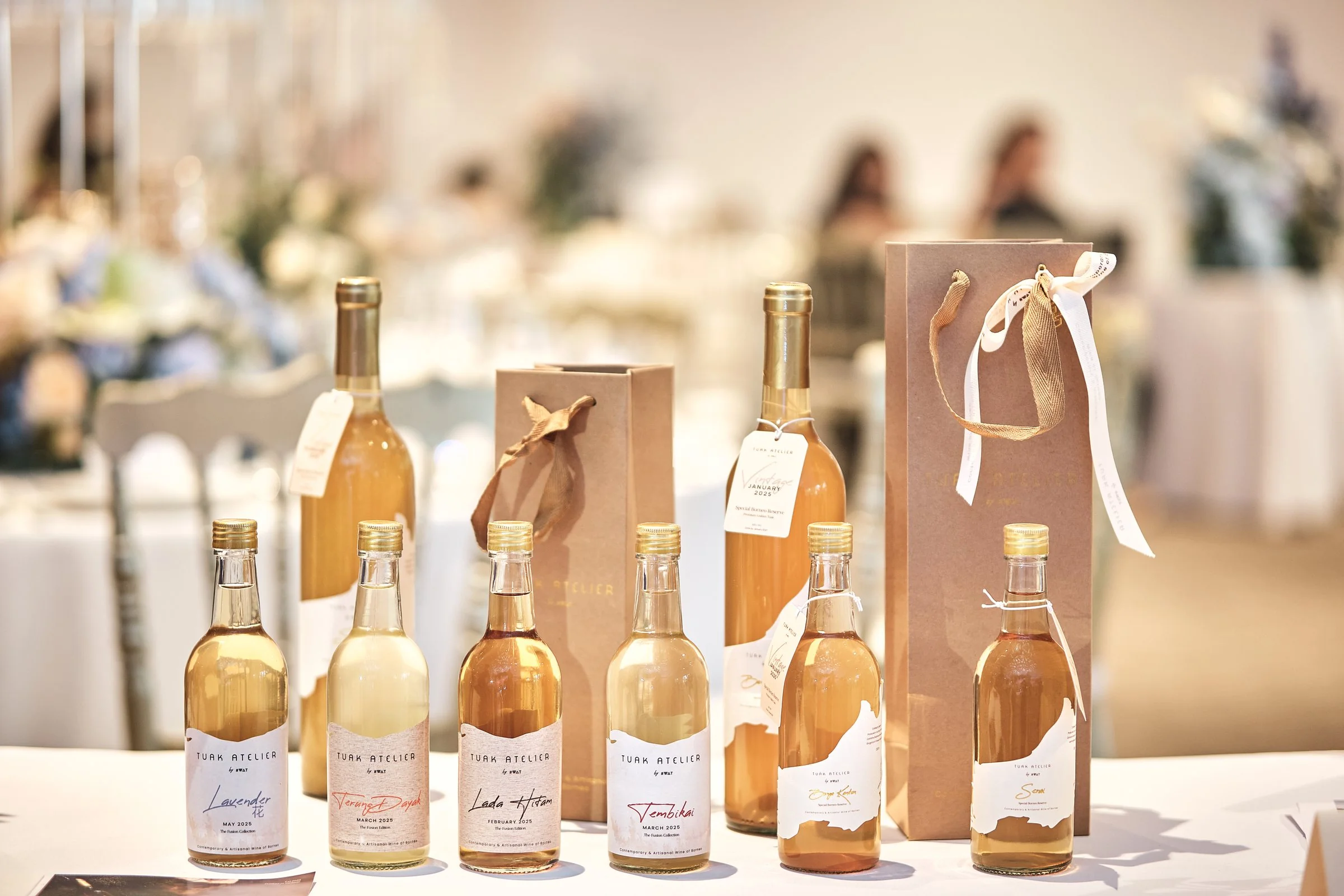 A Tuak Atelier gifting set with personalised bottles and kraft gift bags at a celebration